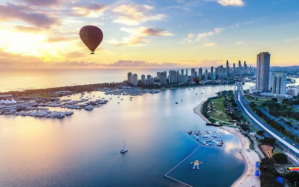 Hot air balloon over Gold Coast skyline at sunrise, Australia.