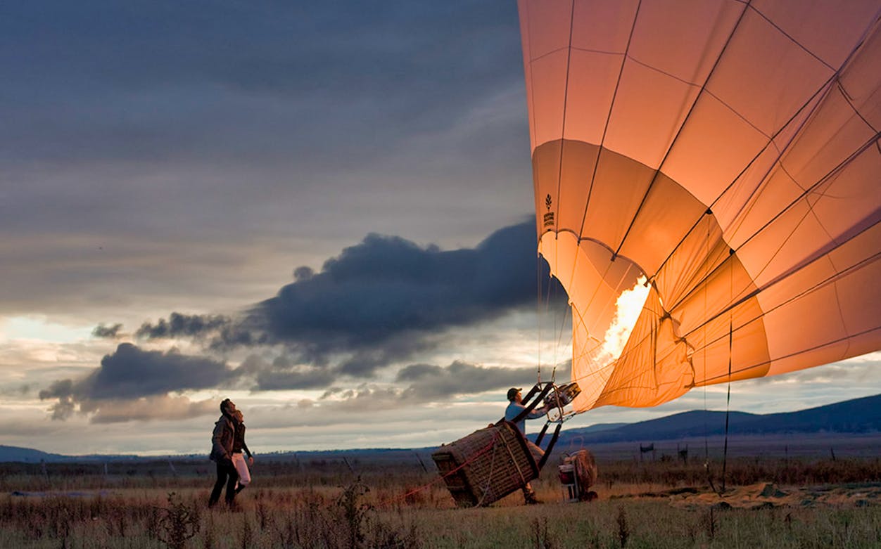 Hot air balloon inflating at sunrise in Melbourne field.
