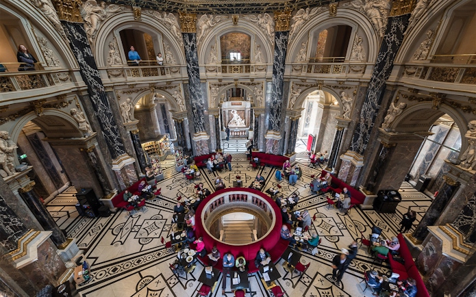Kunsthistorisches Museum interior with ornate architecture and visitors in Vienna.