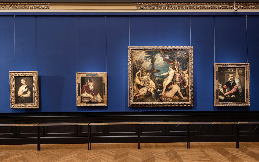 Paintings displayed on a blue wall inside Kunsthistorisches Museum, Vienna.