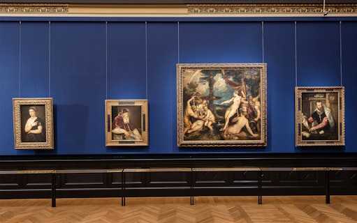 Paintings displayed on a blue wall inside Kunsthistorisches Museum, Vienna.
