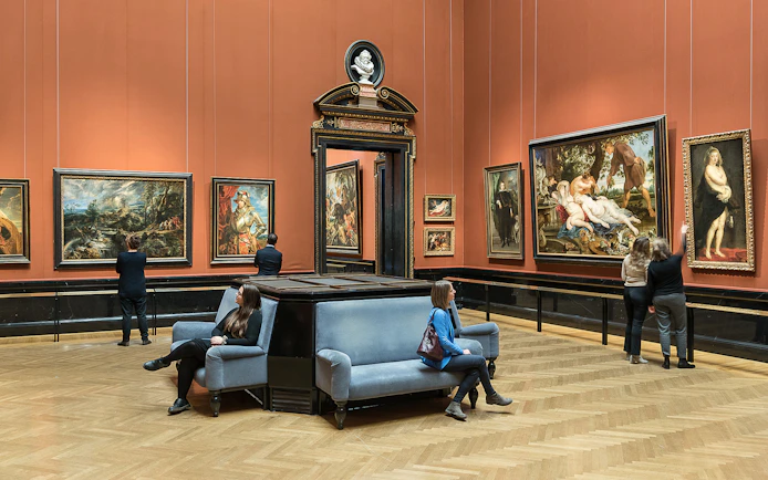 Visitors viewing paintings in a gallery at Kunsthistorisches Museum, Vienna.