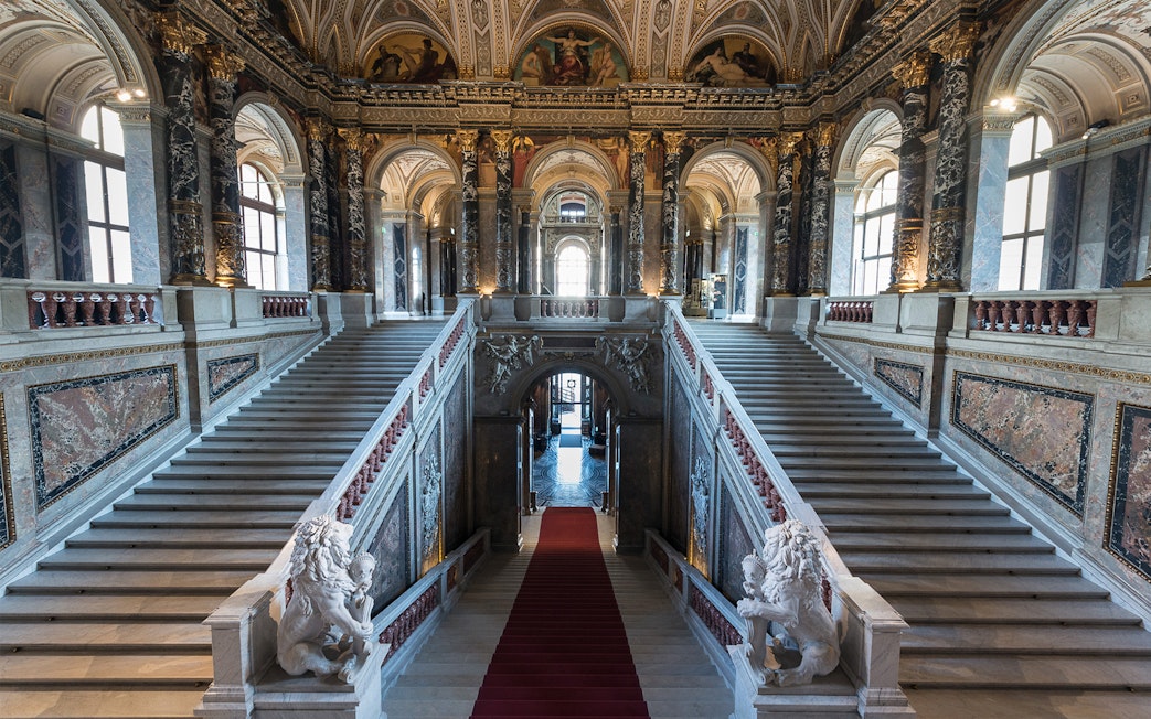 Staircase inside Kunsthistorisches Museum, Vienna, with ornate marble and sculptures.