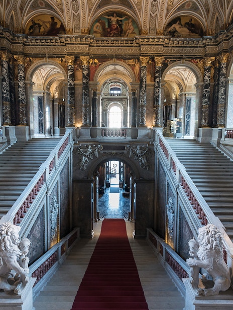 Staircase inside Kunsthistorisches Museum, Vienna, with ornate marble and sculptures.