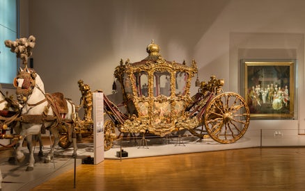 Ornate golden carriage display at Imperial Carriage Museum, Vienna.
