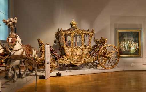 Ornate golden carriage display at Imperial Carriage Museum, Vienna.