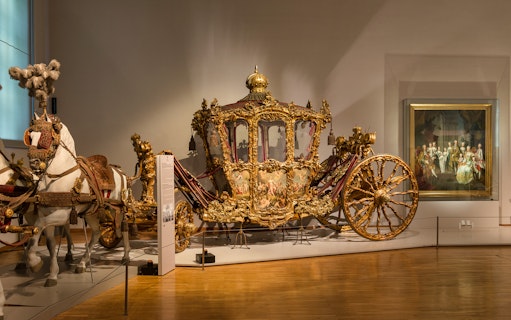 Ornate golden carriage display at Imperial Carriage Museum, Vienna.