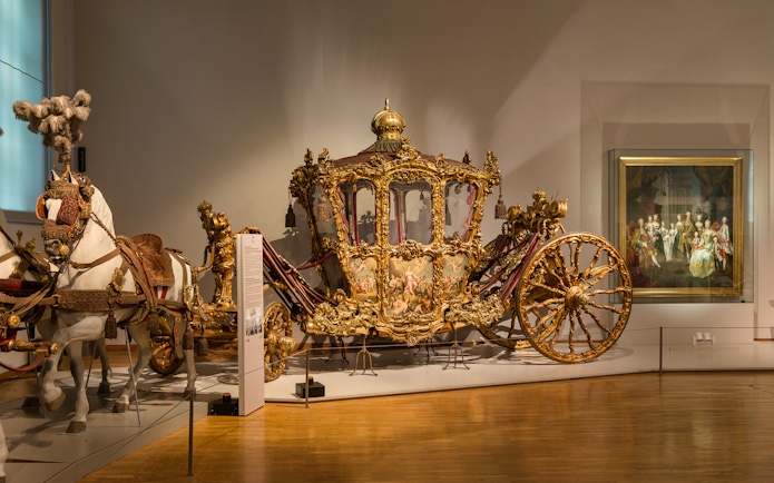 Ornate golden carriage display at Imperial Carriage Museum, Vienna.