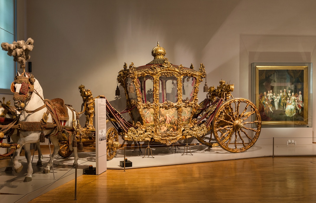 Ornate golden carriage display at Imperial Carriage Museum, Vienna.