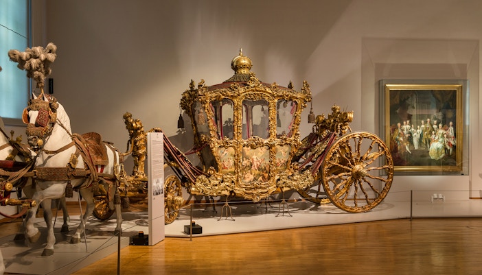 Ornate golden carriage display at Imperial Carriage Museum, Vienna.
