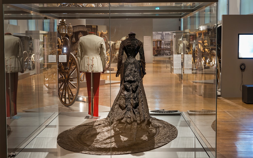 Imperial Carriage Museum display with historical attire and carriages at Schönbrunn Palace.