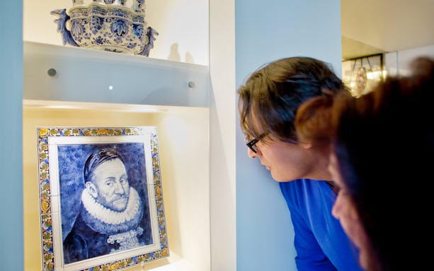 Visitors examining Delft Blue artwork at Royal Delft Blue Factory & Museum.