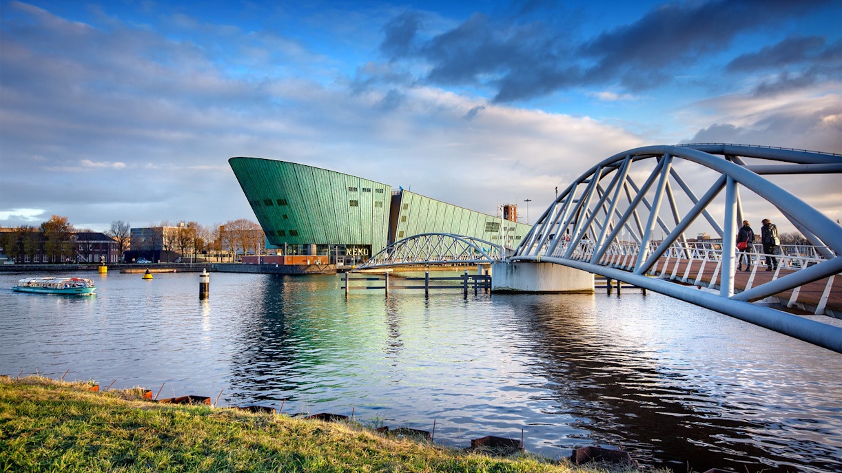 NEMO Science Museum in Amsterdam with pedestrian bridge over water.