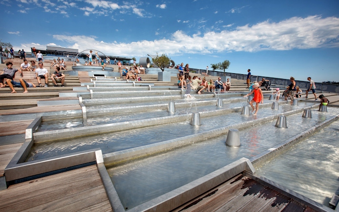 Visitors enjoying the rooftop water feature at NEMO Science Museum, Amsterdam.
