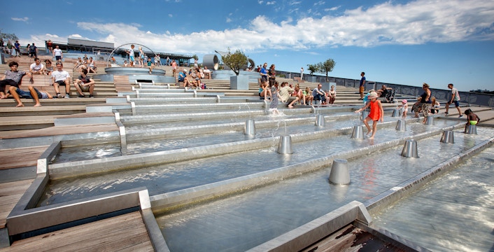 Visitors enjoying the rooftop water feature at NEMO Science Museum, Amsterdam.