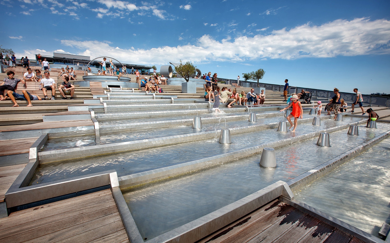 Visitors enjoying the rooftop water feature at NEMO Science Museum, Amsterdam.