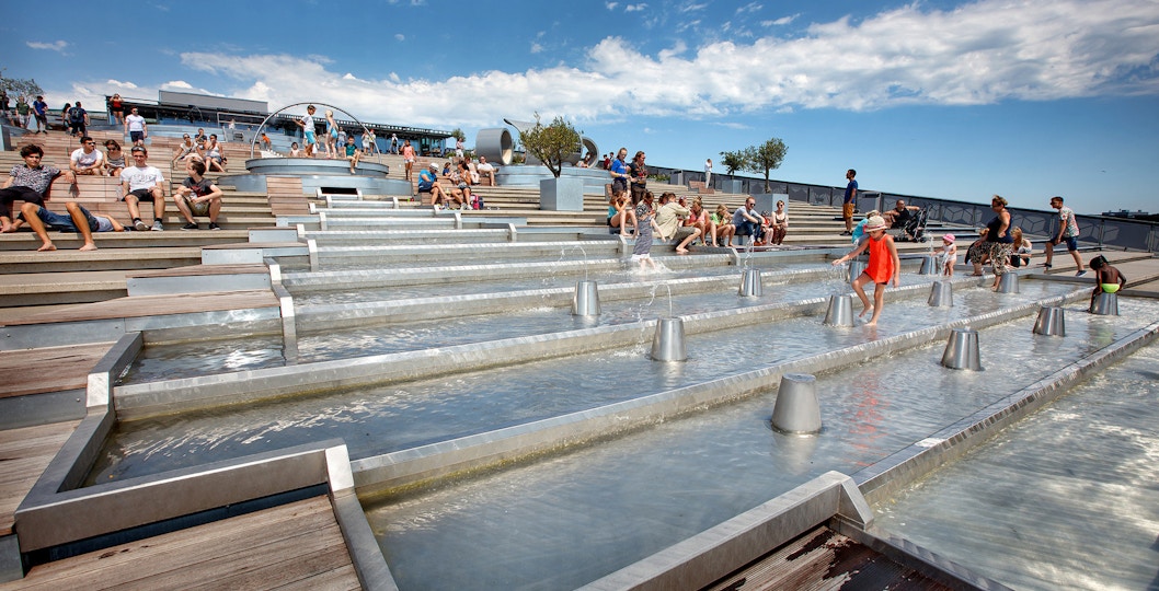 Visitors enjoying the rooftop water feature at NEMO Science Museum, Amsterdam.