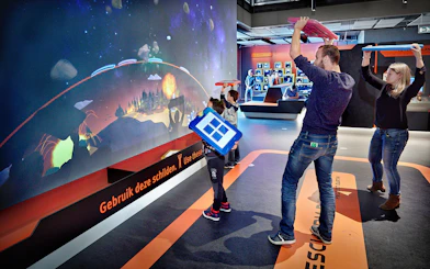 Visitors engaging with interactive exhibit at NEMO Science Museum, Amsterdam.