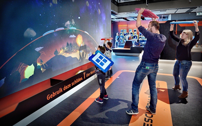Visitors engaging with interactive exhibit at NEMO Science Museum, Amsterdam.
