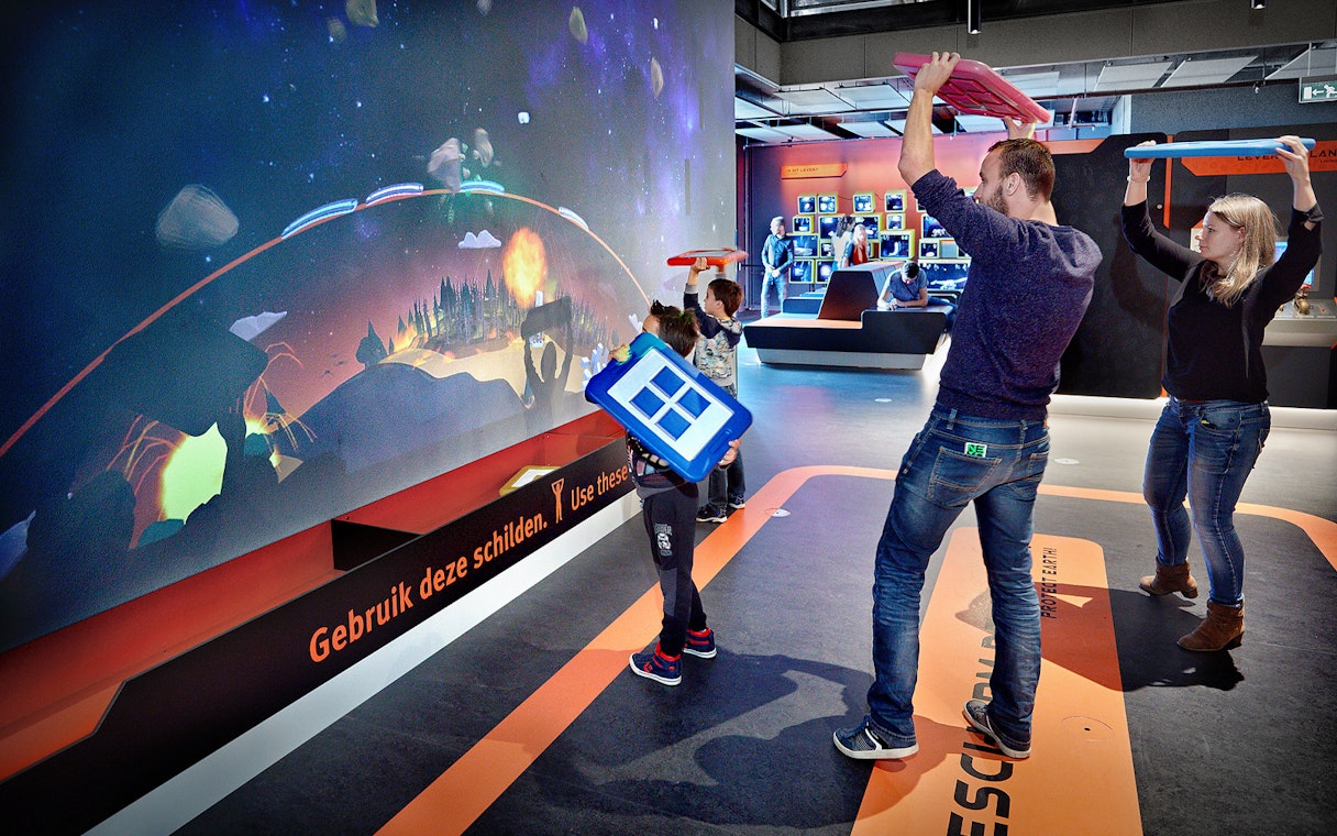 Visitors engaging with interactive exhibit at NEMO Science Museum, Amsterdam.
