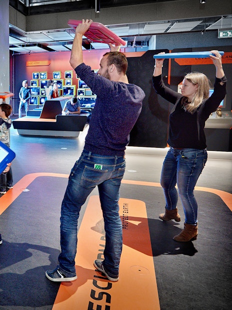 Visitors engaging with interactive exhibit at NEMO Science Museum, Amsterdam.