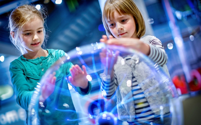 Children interacting with a plasma globe at NEMO Science Museum, Amsterdam.