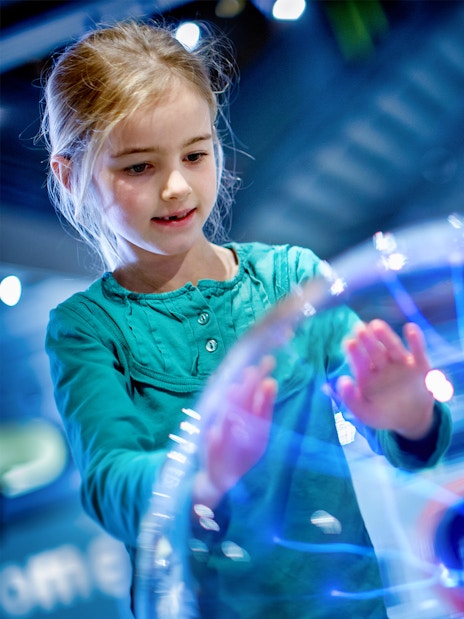 Children interacting with a plasma globe at NEMO Science Museum, Amsterdam.