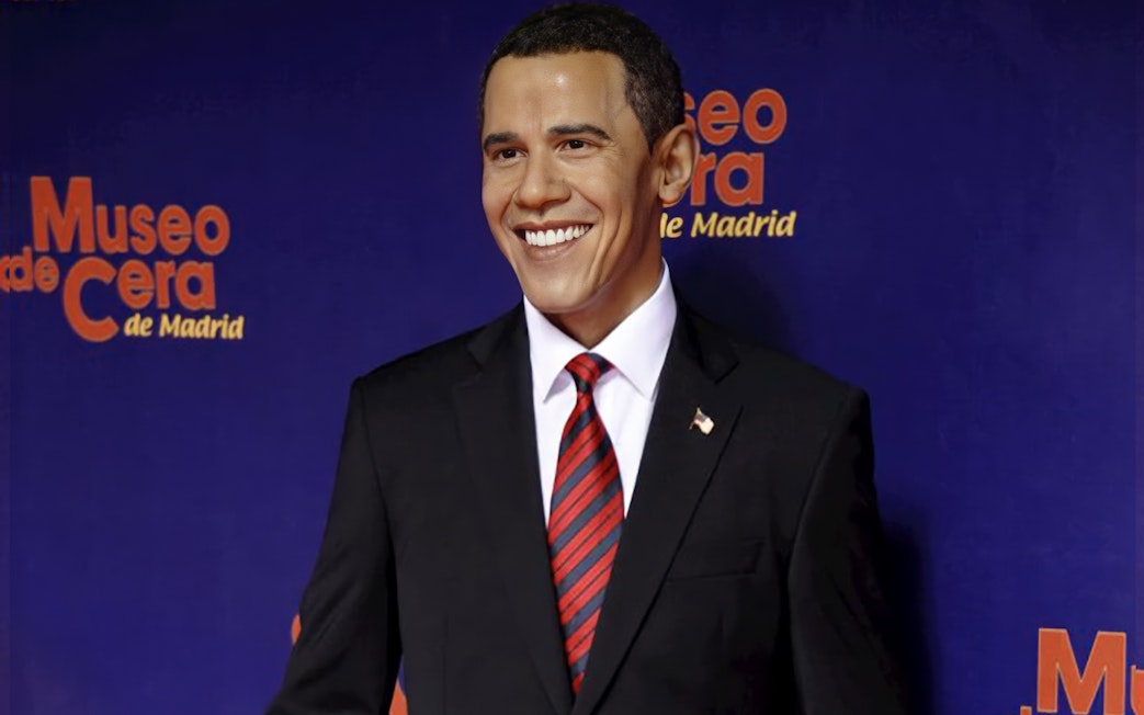 Wax figure of a smiling man in a suit at Madrid Wax Museum.