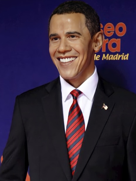 Wax figure of a smiling man in a suit at Madrid Wax Museum.