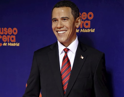 Wax figure of a smiling man in a suit at Madrid Wax Museum.