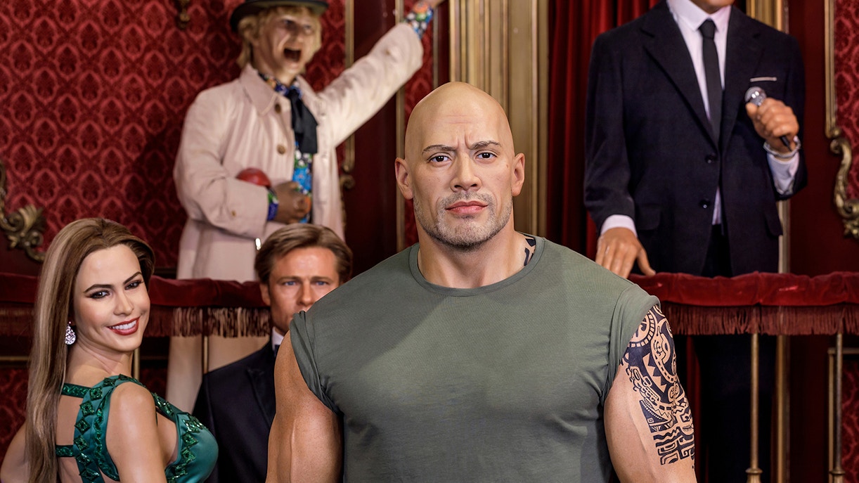 Dwayne Johnson wax figure at Wax Museum Madrid with visitors in the background.