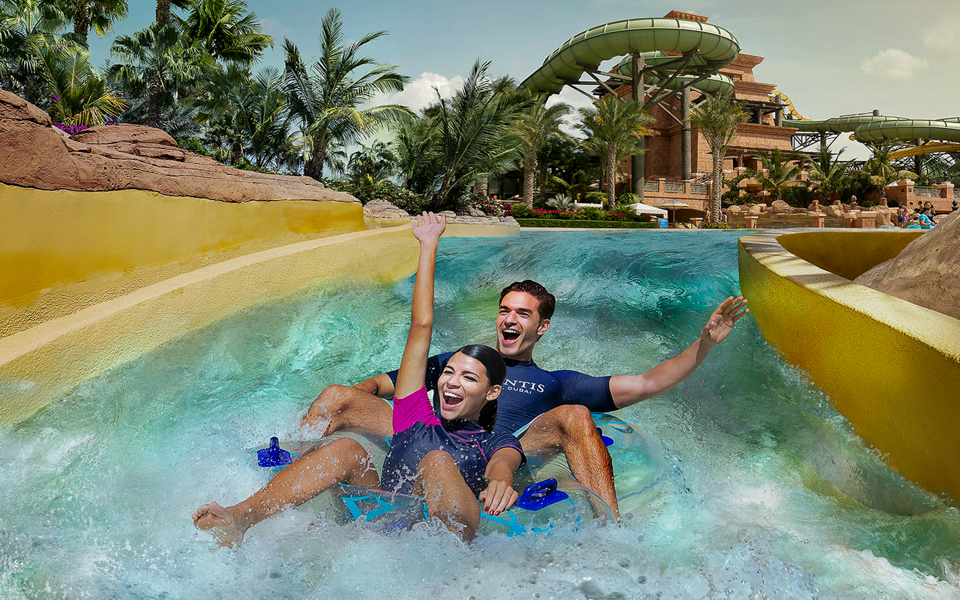 Couple enjoying water slide at Aquaventure Waterpark, Dubai.