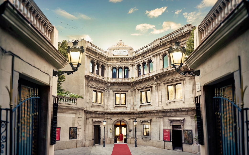 Entrance of Wax Museum in Barcelona with ornate facade and red carpet.