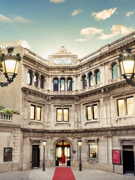 Entrance of Wax Museum in Barcelona with ornate facade and red carpet.