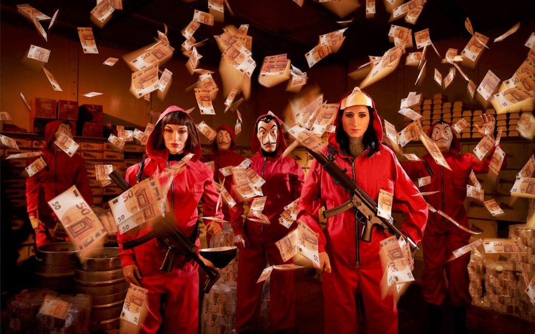 Wax figures in red jumpsuits with masks and money at Wax Museum Barcelona.