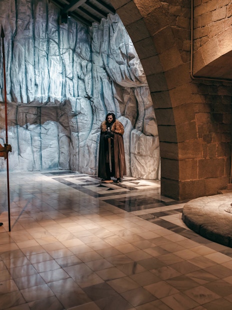 Wax figures in medieval attire near a throne at Wax Museum Barcelona.