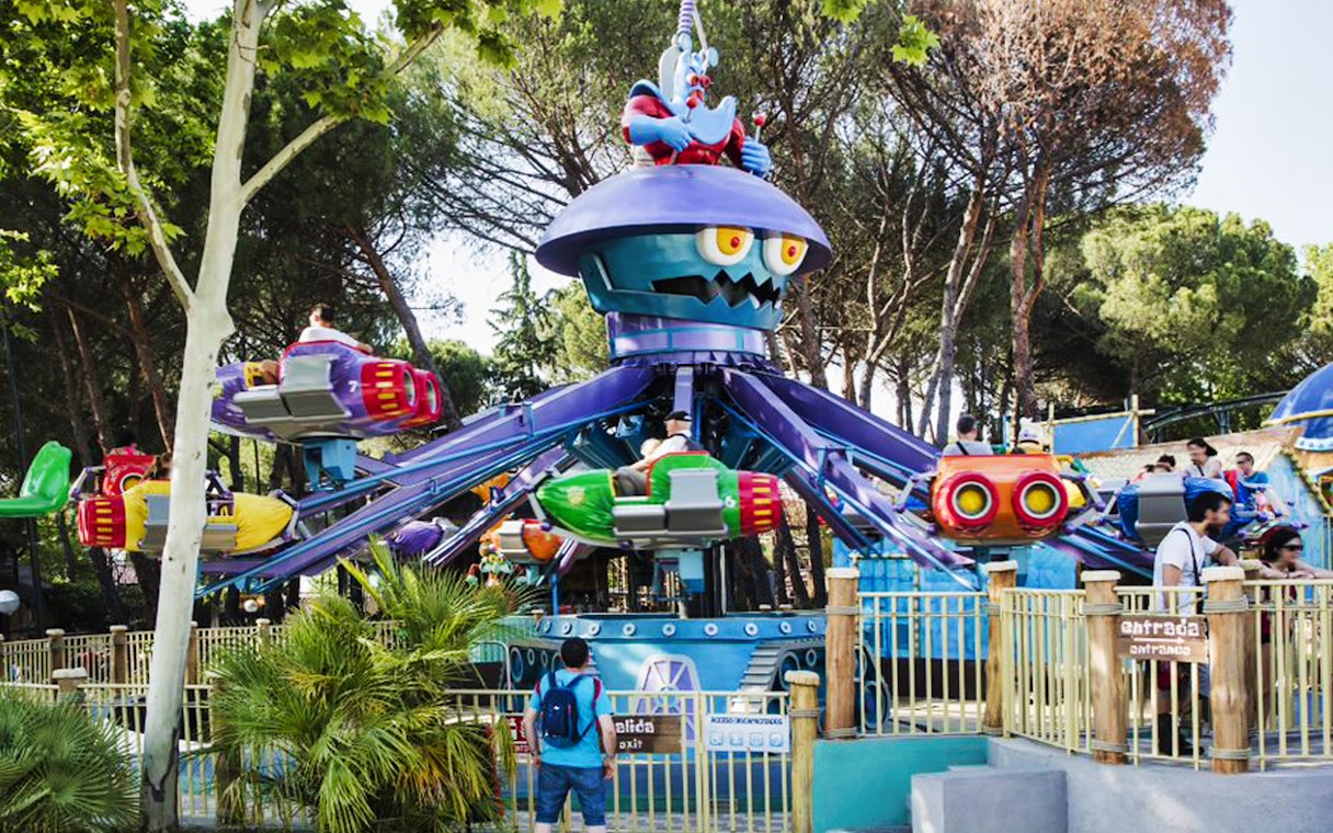 Visitors on colorful rides at Parque de Atracciones de Madrid with skip-the-line access.