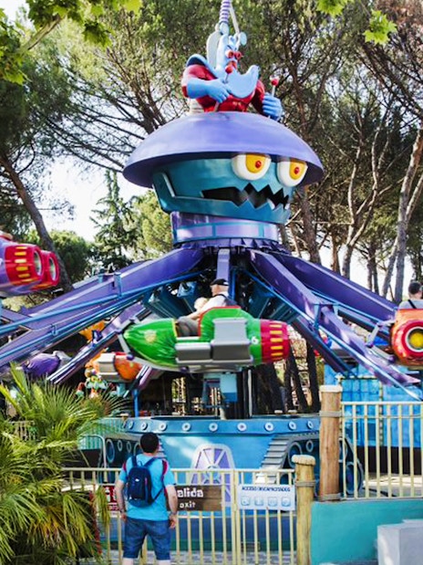 Visitors on colorful rides at Parque de Atracciones de Madrid with skip-the-line access.