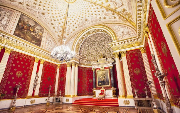 Hermitage Museum's ornate red and gold interior with chandeliers and artwork.