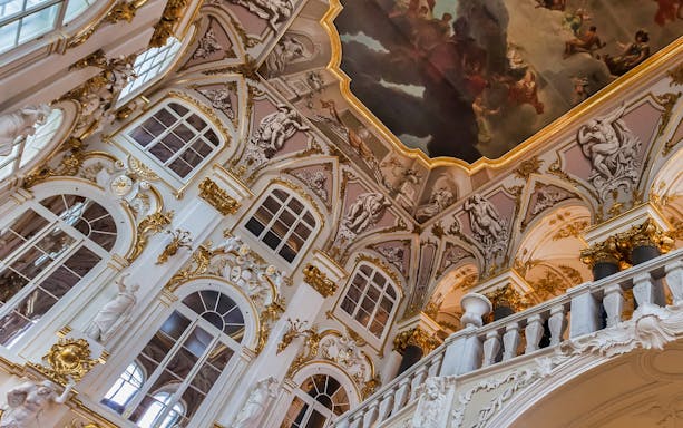 Hermitage Museum ornate interior with detailed ceiling fresco and sculptures.
