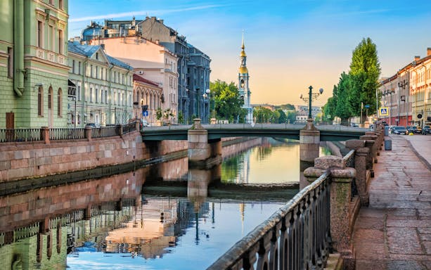 Canal view with historic buildings and church spire in Saint Petersburg, Russia.