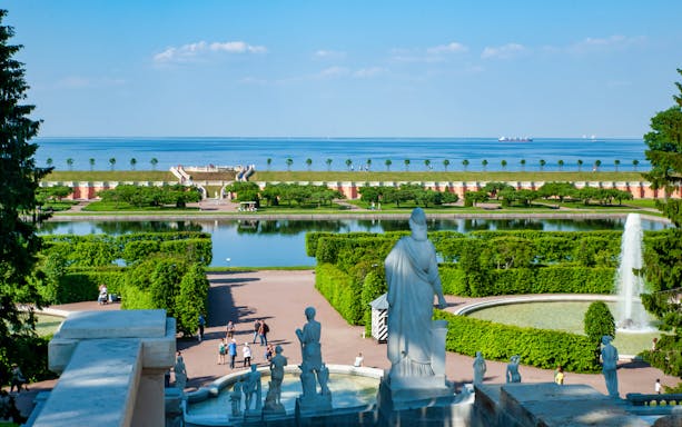 Great Peterhof Palace view with statues, fountains, and gardens leading to the Gulf of Finland.