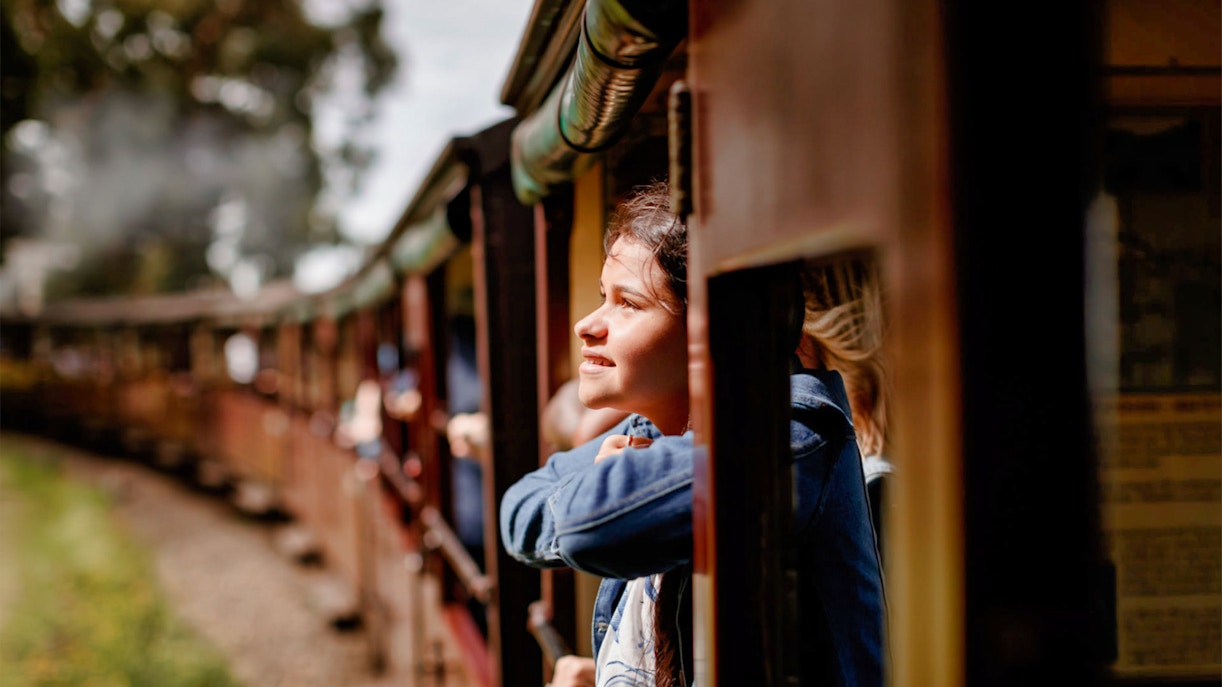 Person enjoying the view from Puffing Billy Railway train window.