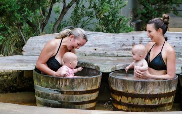 Women and babies enjoying wooden barrel baths at Mornington Peninsula Hot Springs.