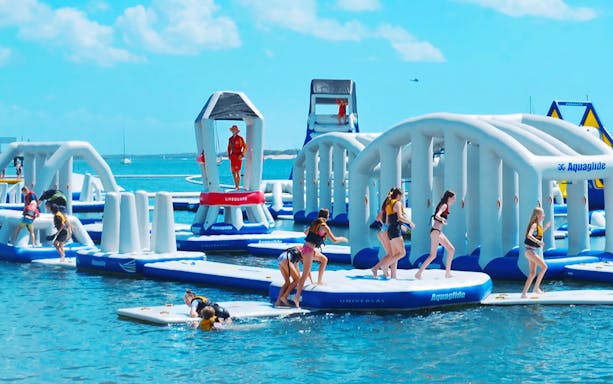 Visitors enjoying inflatable obstacle course at Gold Coast Aqua Park.