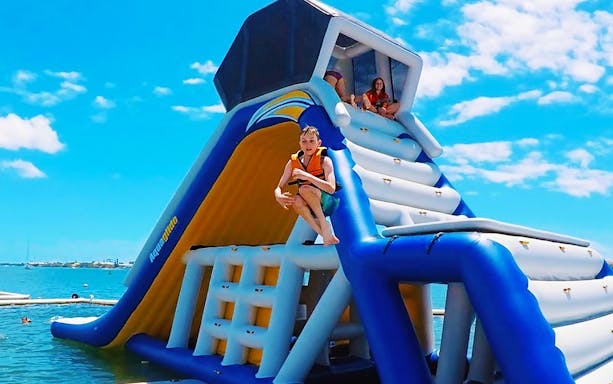 Person jumping off inflatable slide at Gold Coast Aqua Park.