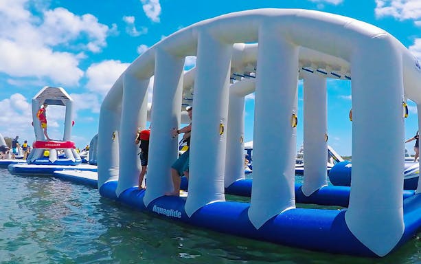 Visitors enjoying inflatable obstacle course at Gold Coast Aqua Park.