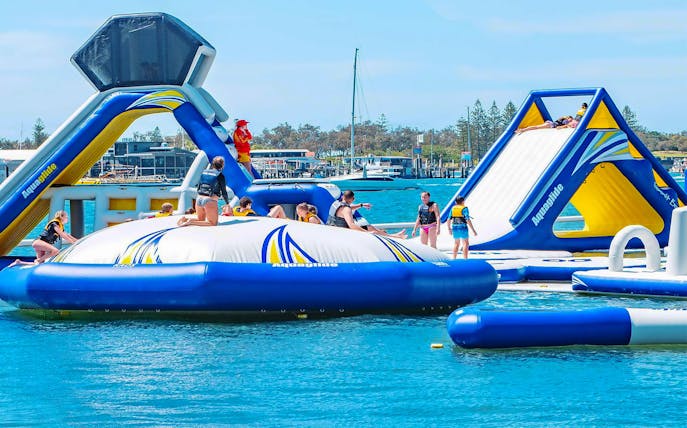 Visitors enjoying inflatable water park at Gold Coast Aqua Park.