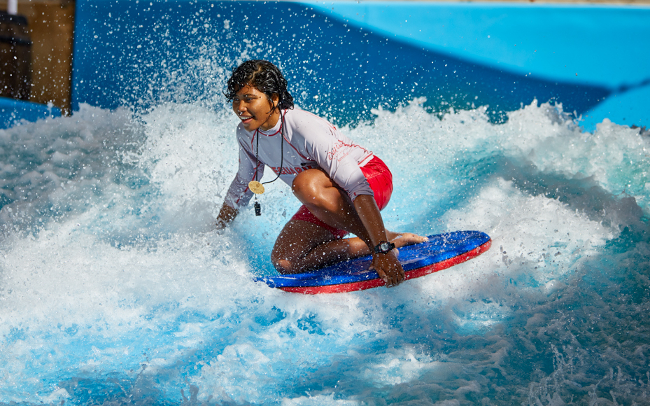 Person surfing on artificial wave at Wild Wadi Waterpark, Dubai.
