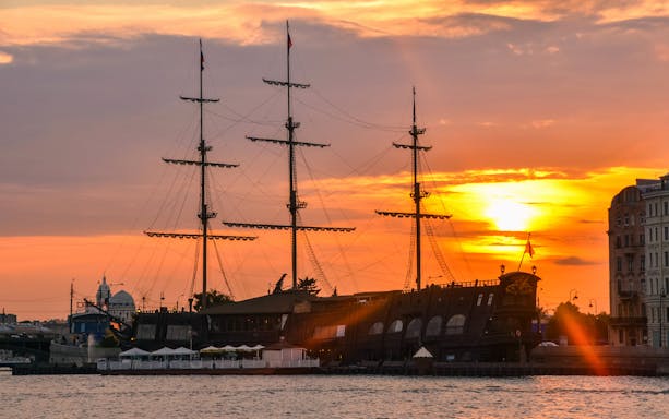 Tall ship docked at sunset during a sightseeing river and canal cruise.